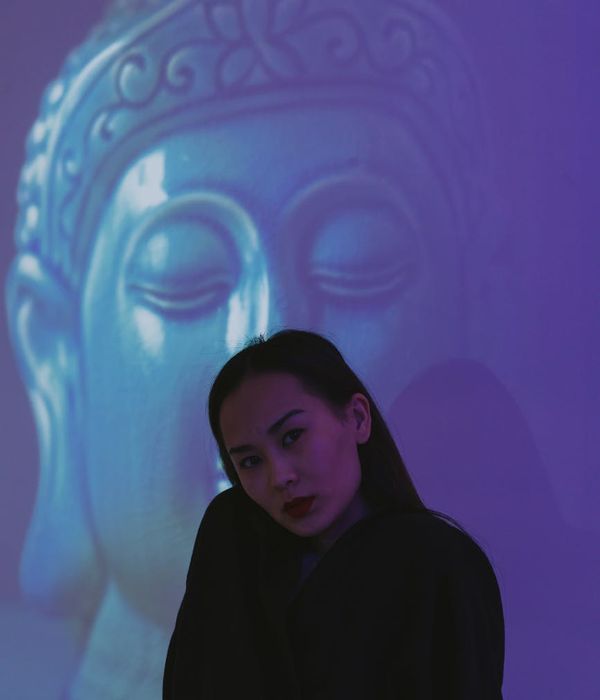 Woman in a calm pose against a light blue background.